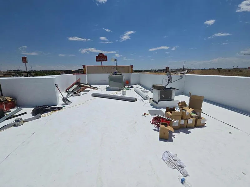 White PVC membrane installed on a commercial flat roof with parapet walls